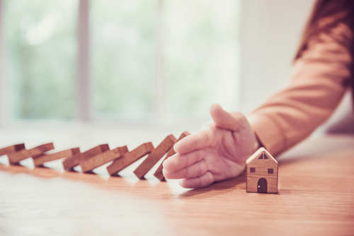 Woman,Hand,Stopping,Risk,The,Wooden,Blocks,From,Falling,On