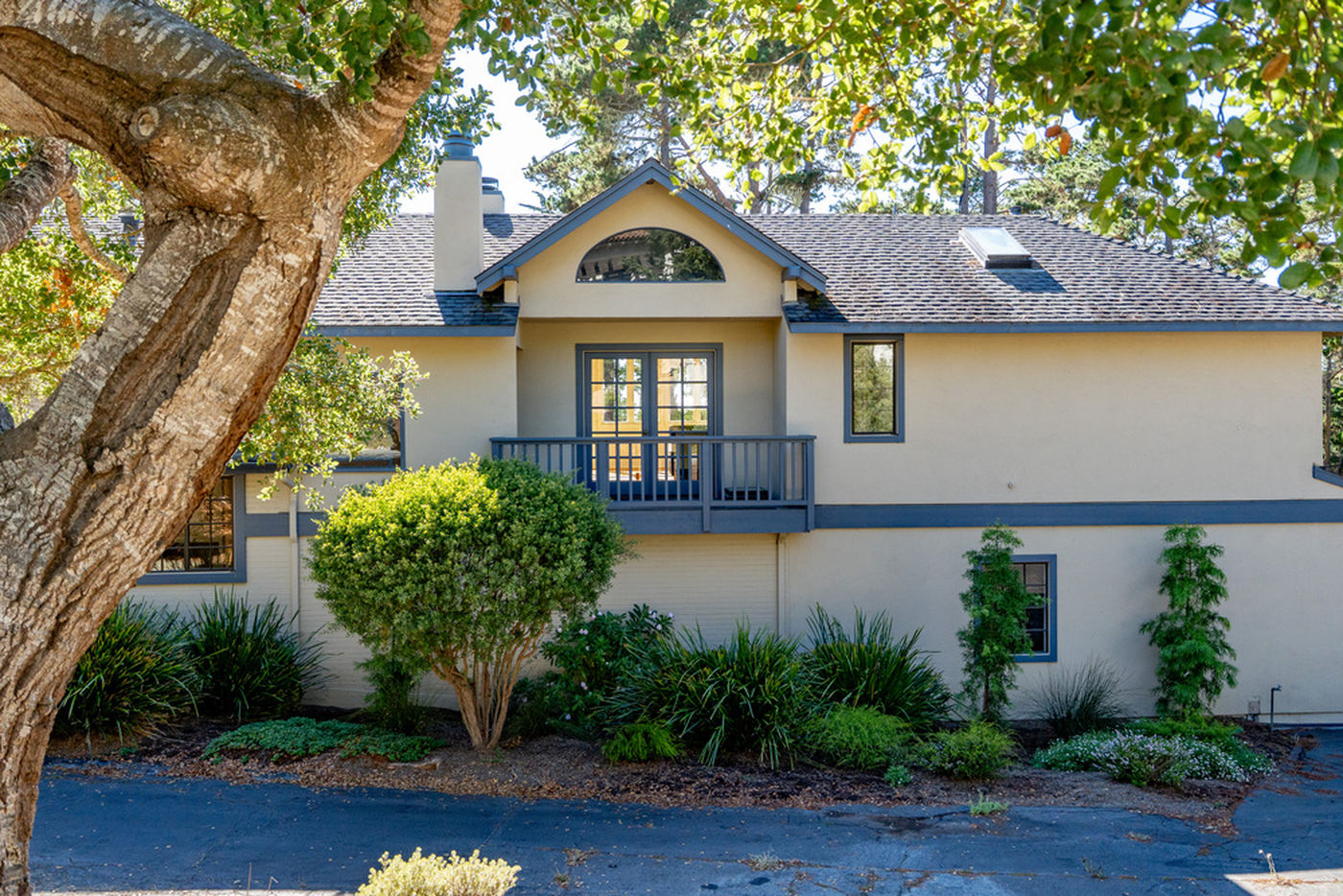 Front of the home at 1424 Oleada Road, Pebble Beach, framed by an oak tree
