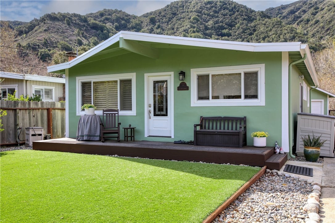 Green cottage at 79 Paso Hondo with the Carmel Valley hills behind it