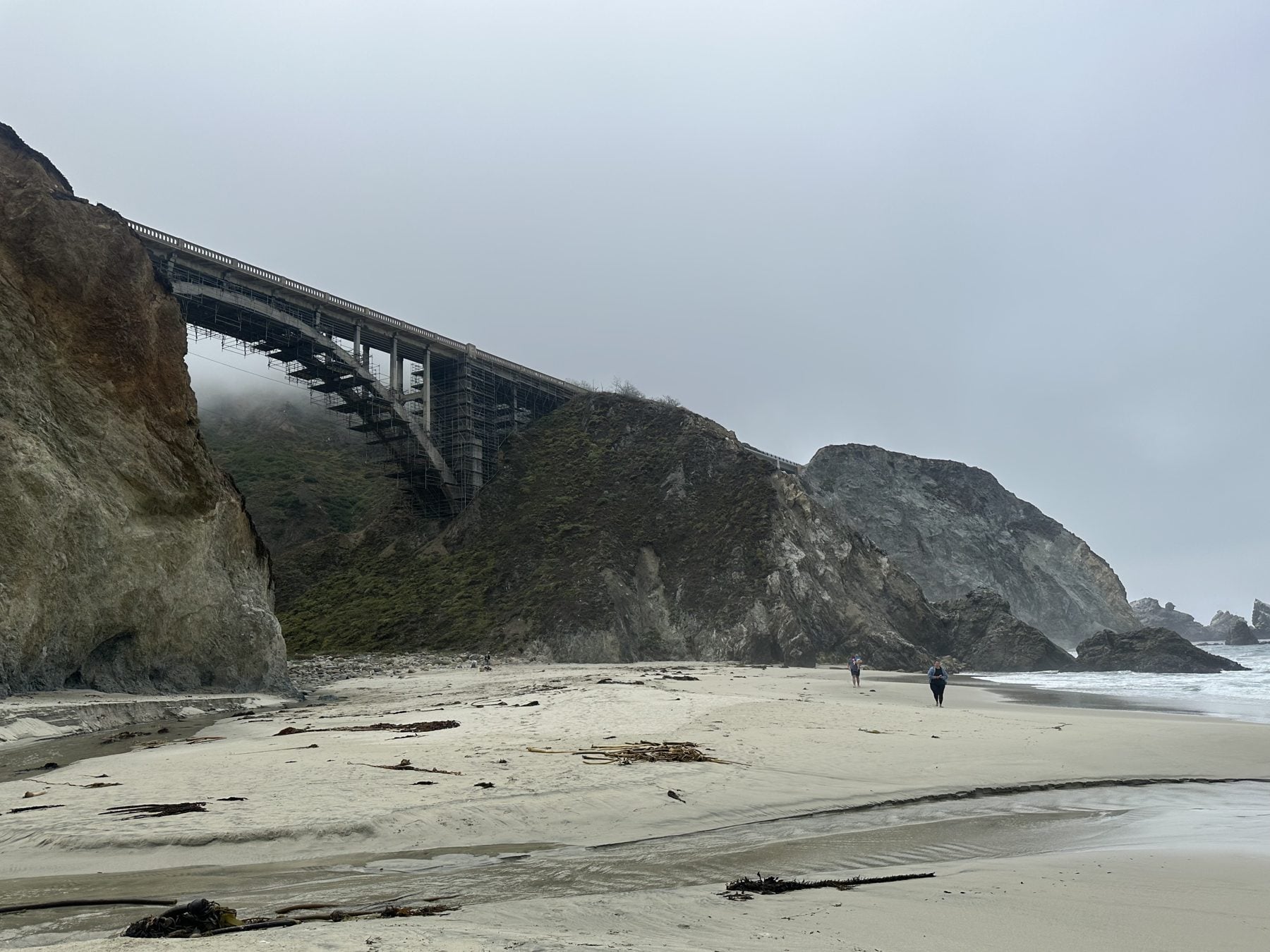 Foggy hidden beach below a Highway 1 bridge on the drive into Big Sur
