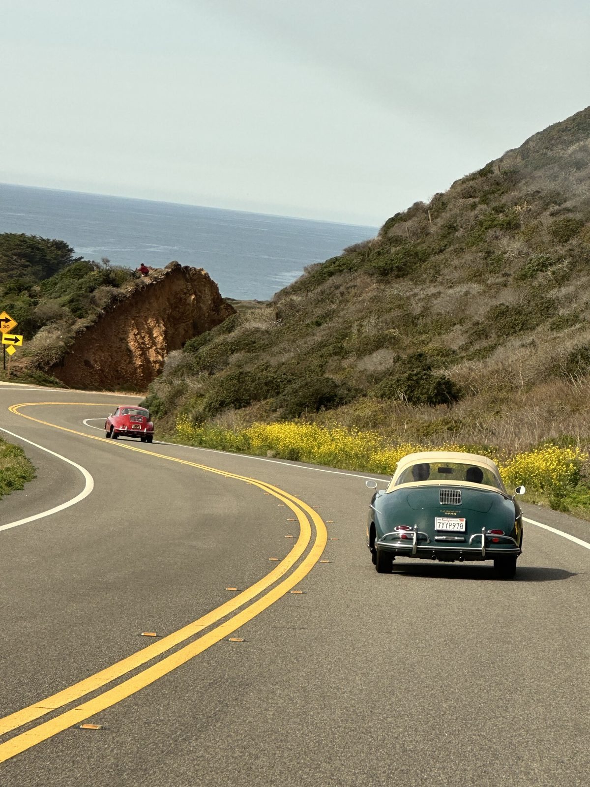 Two Porsche 356s, a coupe and a cabriolet, on Highway 1 heading back from Big Sur