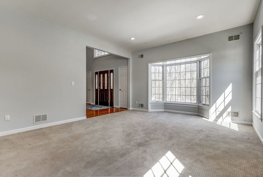 Living room with front door and bay window