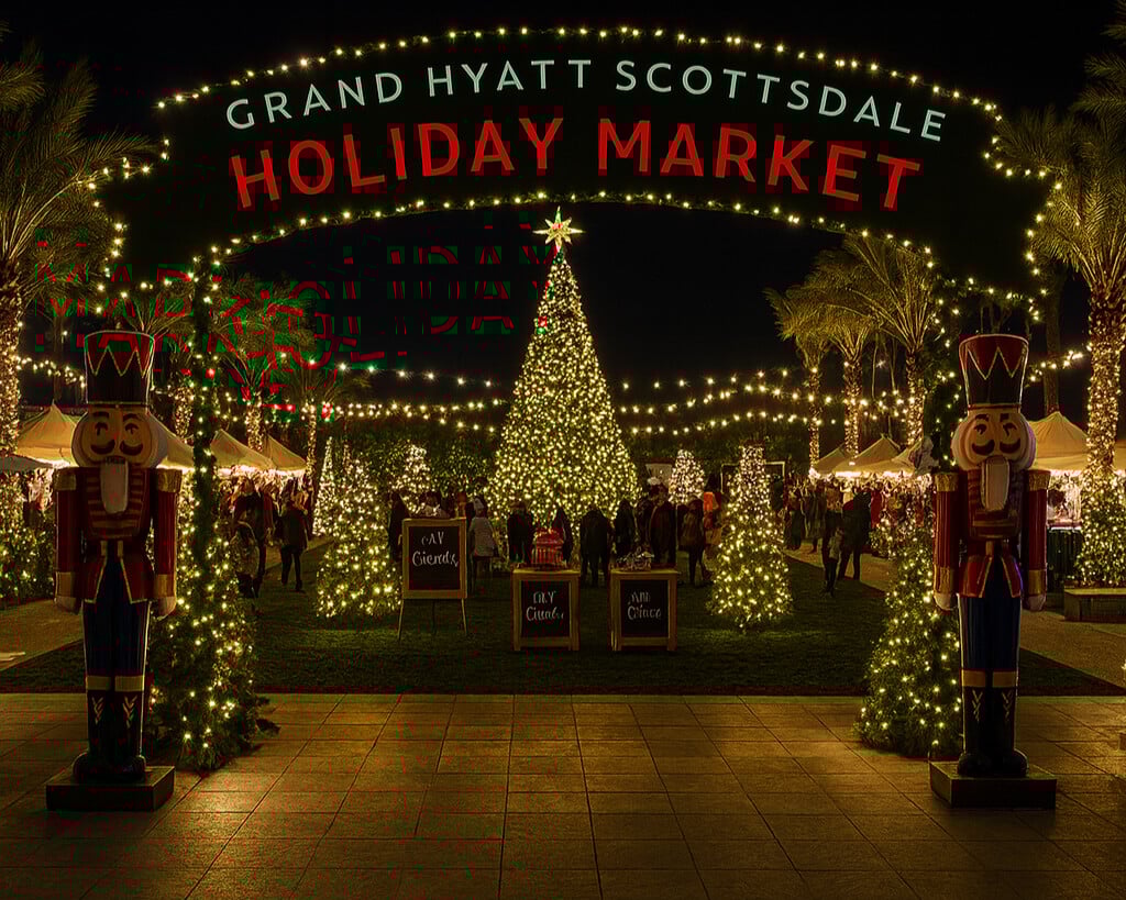 Hand-lit luminarias lining the Entrance at night.