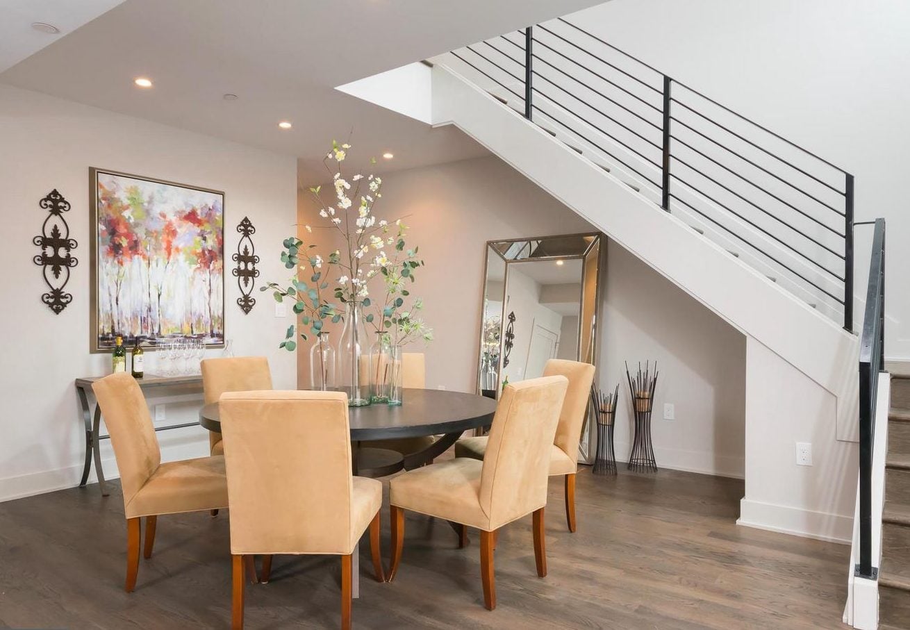 Photograph - Tranquil home with a large dining table, chairs, a canvas painting and a staircase