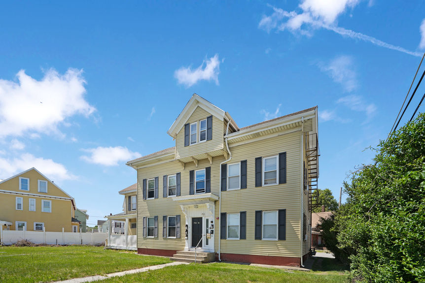 Side exterior and fire escape at 62 Conant St, Pawtucket, listed by Alexander Parmenidez, Coldwell Banker Realty.