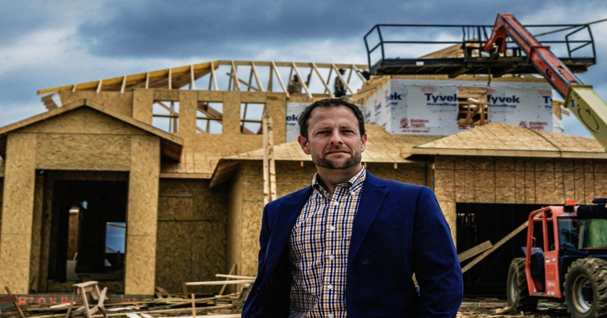 Brian Carlin standing in front of new construction home