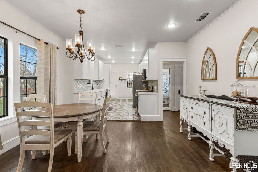 Bright dining room with classic chandelier and view into the kitchen at 2234 Harrell St.