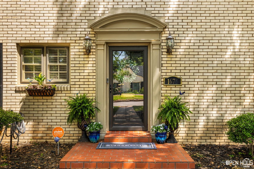 Detailed shot of the arched front door with sidelights, black shutters, and decorative brickwork.