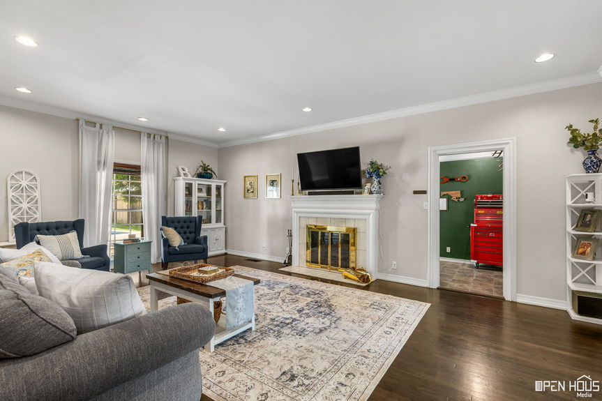Spacious living room with a fireplace, hardwood floors, and built-in shelving.