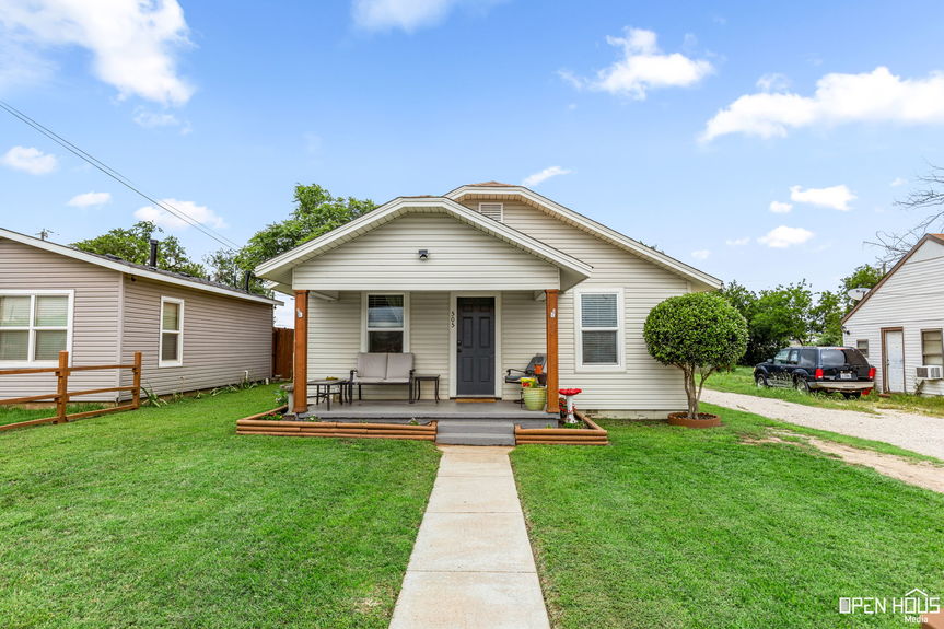 Front yard of a home with colorful flower beds and a well-kept lawn.