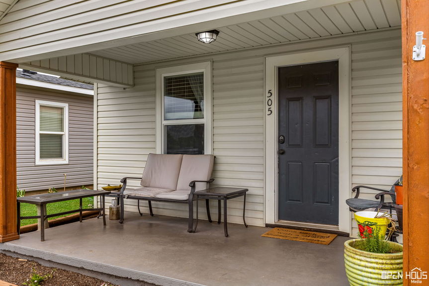 Close-up of the house's front porch with seating and decorative plants.