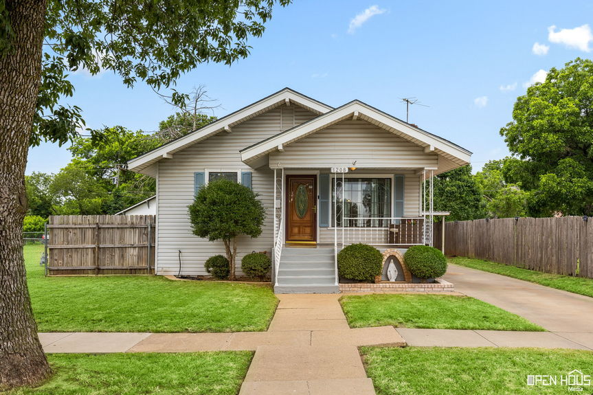 Front view of 1208 Tyler Ln, showing the house with a fenced yard and a covered porch.