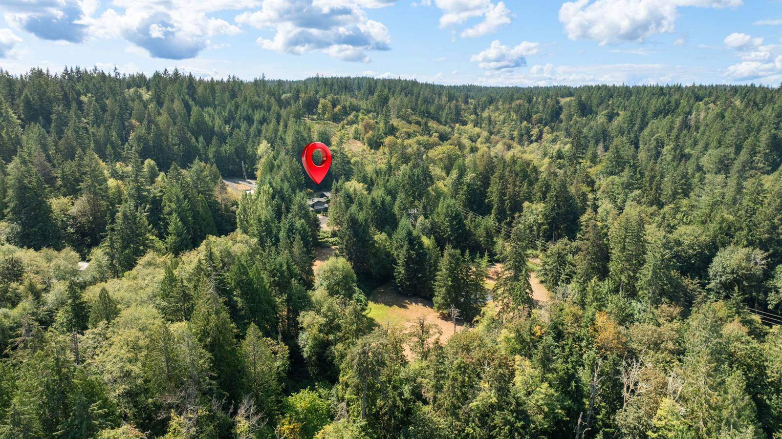 High aerial of the property surrounded by forest