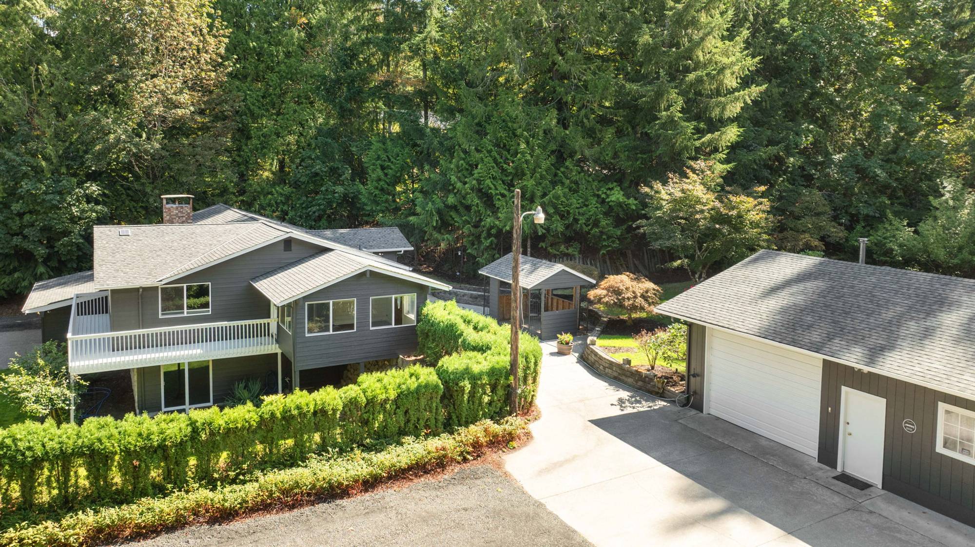 Aerial view of the home, detached garage and gazebo at 4803 Feigley Rd W surrounded by evergreens
