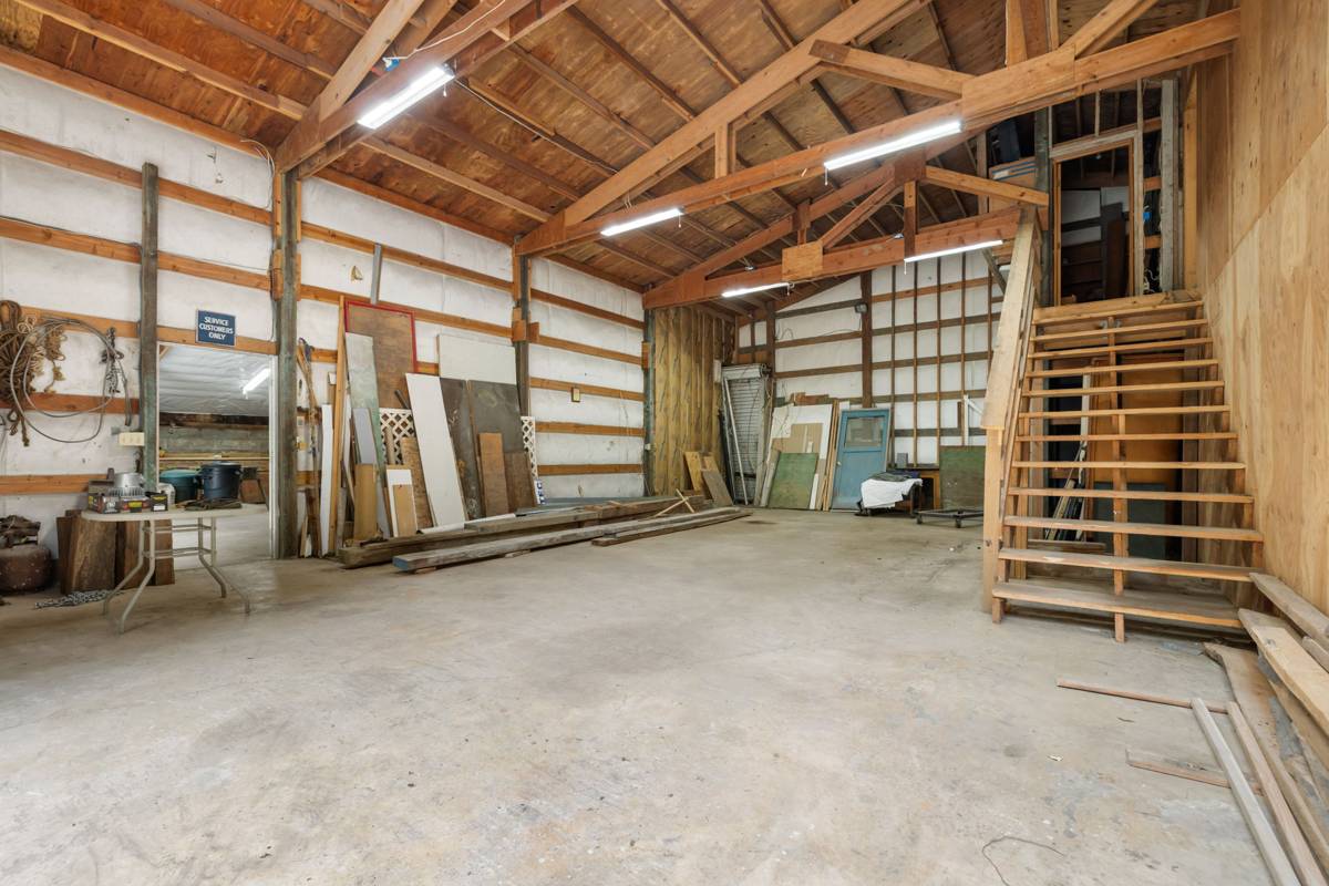 Wood-framed shop interior with stairs to a loft