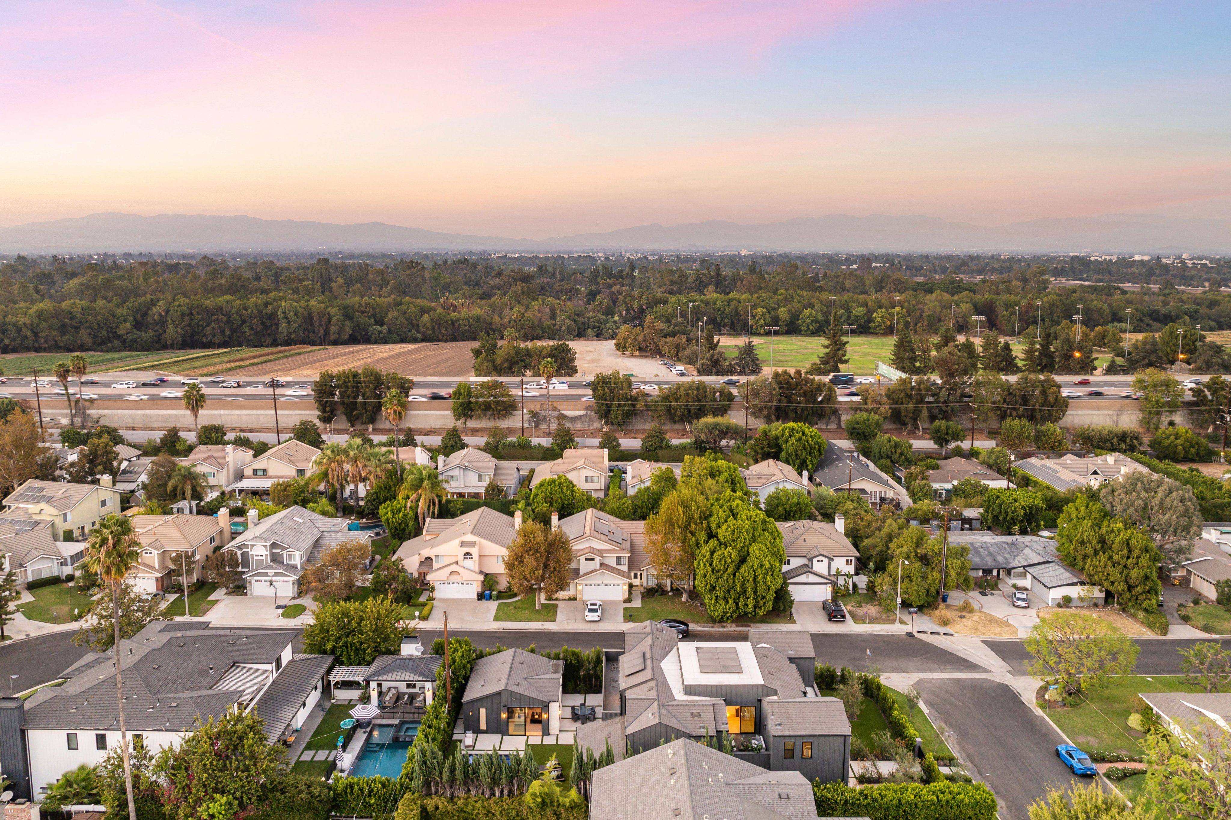 Aerial view of suburban homes with sunset sky.