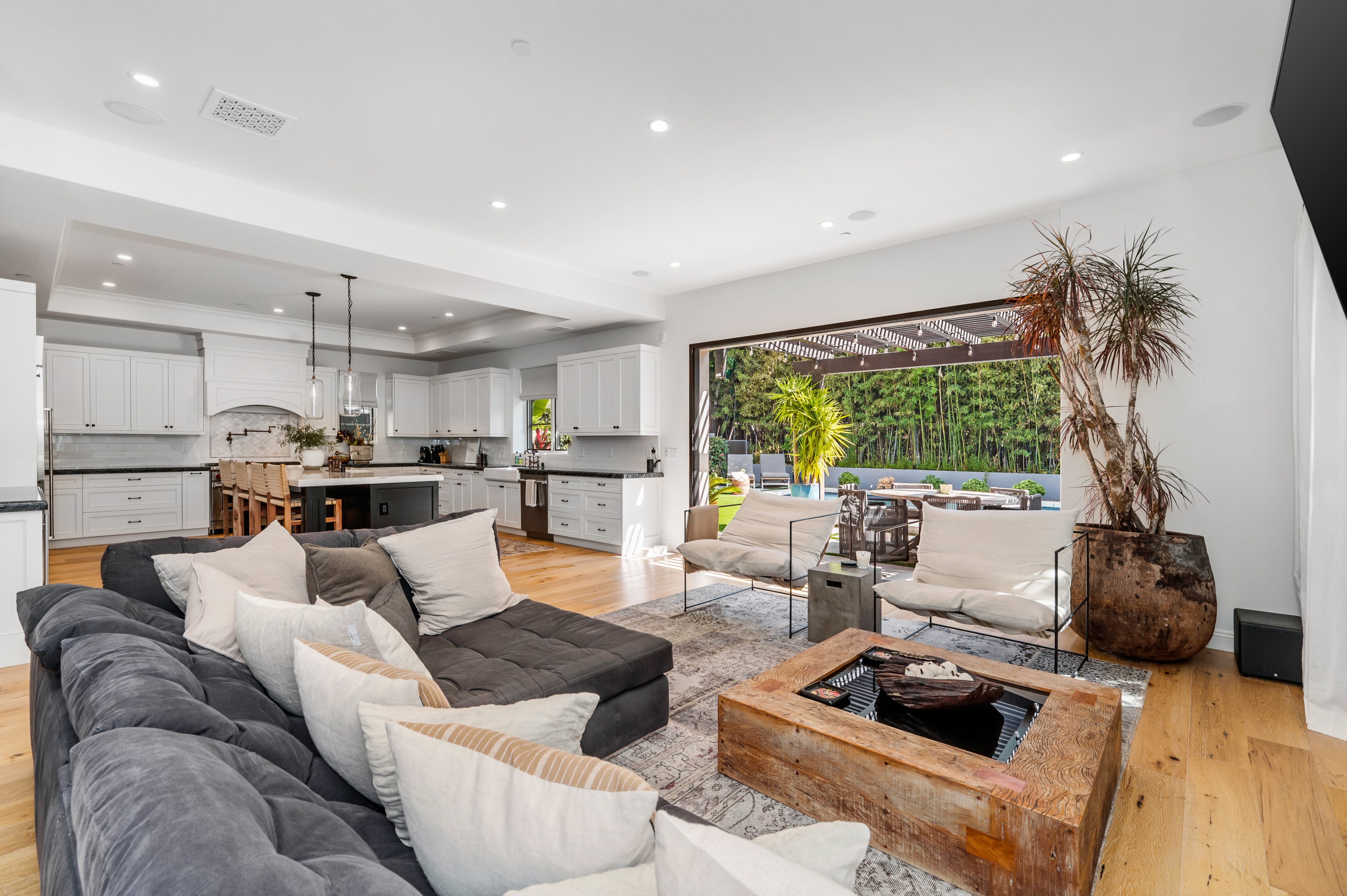 this is a living room filled with lots of furniture and large windows