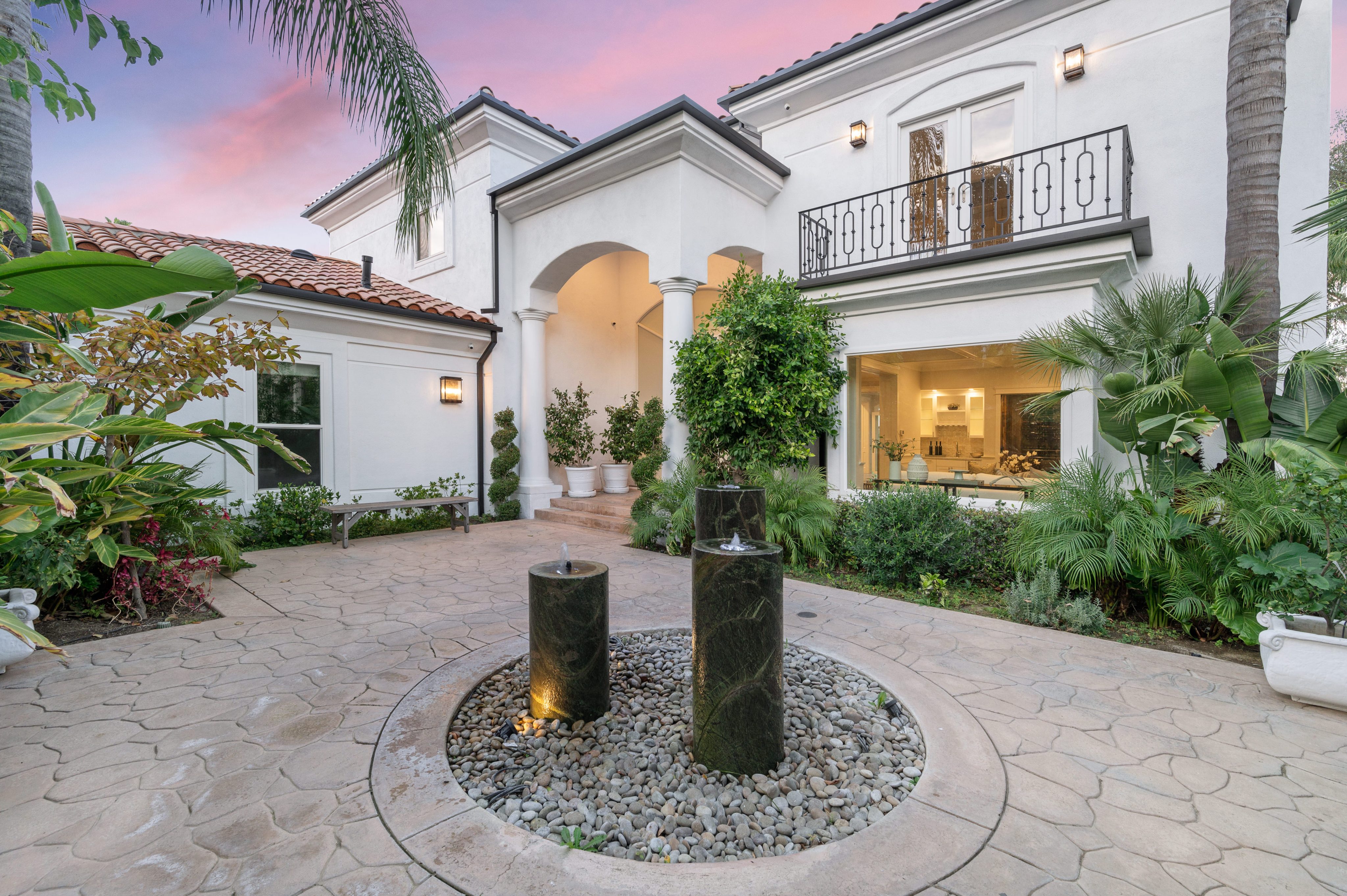 Modern house facade at dusk with lush foliage