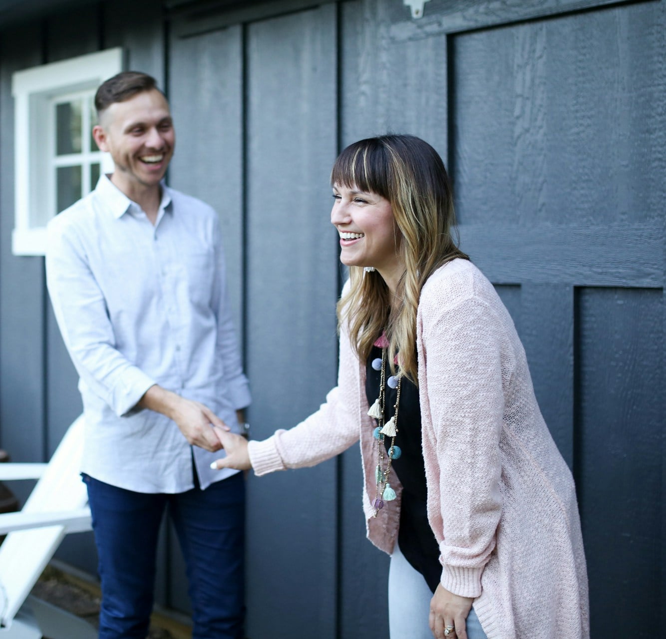 Smiling couple greeting a friend outside their new home after relocating to Pittsburgh's North Hills