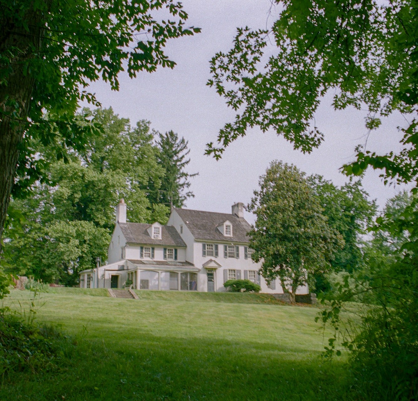 White colonial home on a private wooded lot with expansive lawn near Bradford Woods, PA