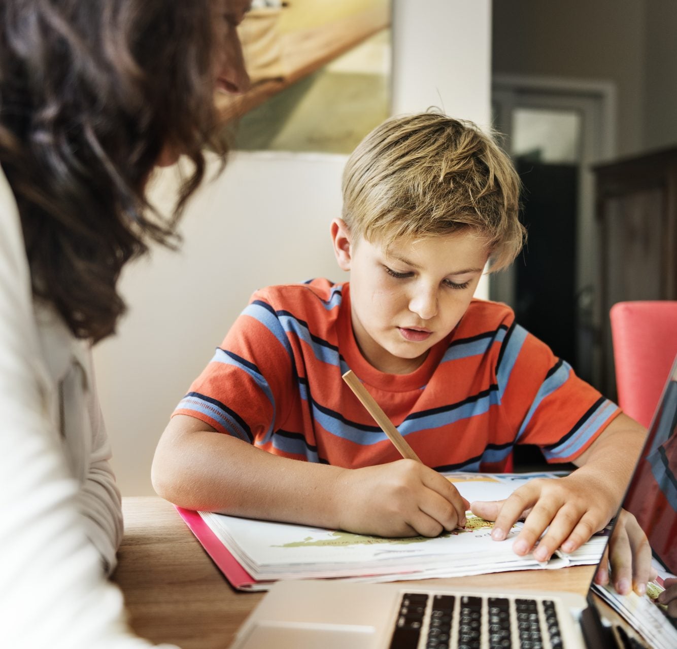 Parent helping a child with homework at the kitchen table in a Seneca Valley School District home