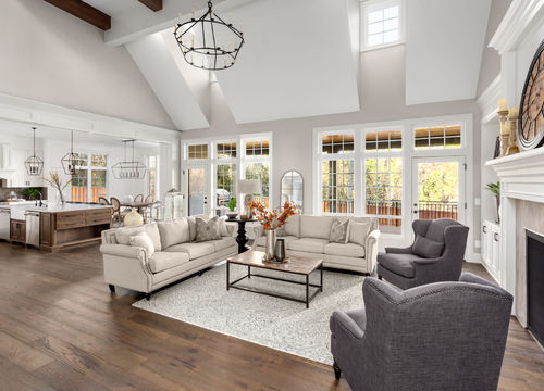 Beautiful living room and kitchen in new traditional style luxury home. Features vaulted ceilings and elegant furnishings.
