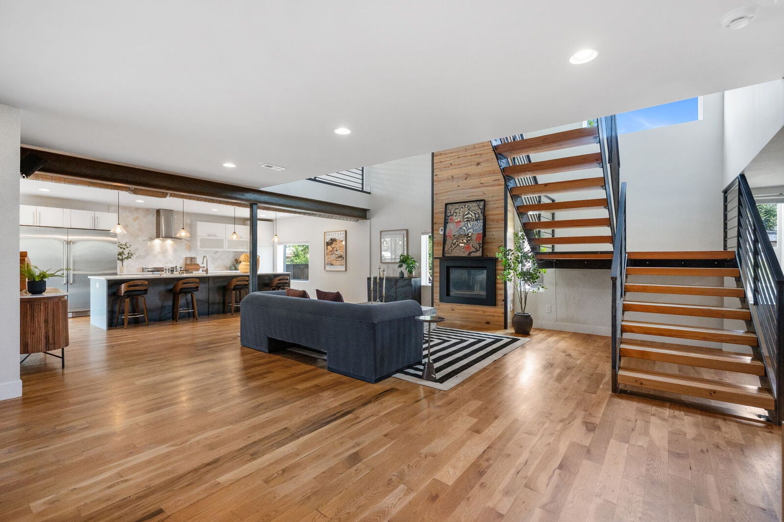 Double-height living room with architectural beams and fireplace at 3801 W Alice Pl in Berkeley, Denver