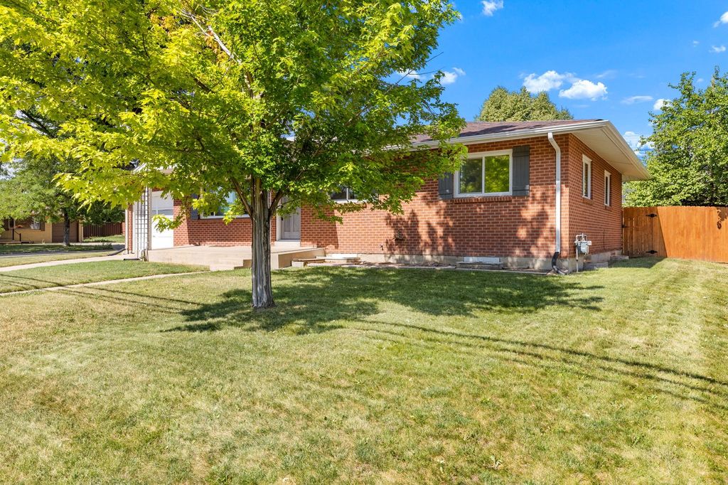 Large backyard with mature shade trees behind an Applewood brick ranch in Jefferson County, Colorado