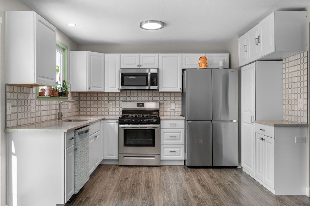 Updated white kitchen with stainless appliances in an Applewood home after a minor kitchen refresh