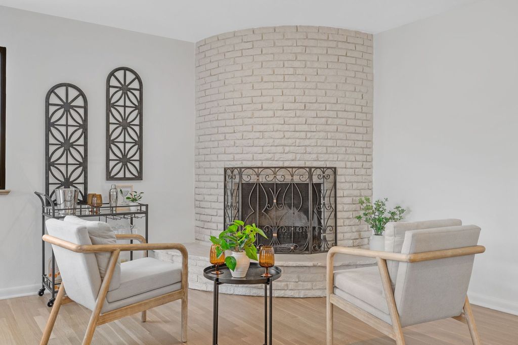 Refreshed living room with painted brick fireplace in a Denver home prepared for listing