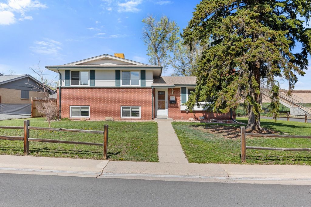 Two-story brick home with mature evergreens in south central Denver, Colorado