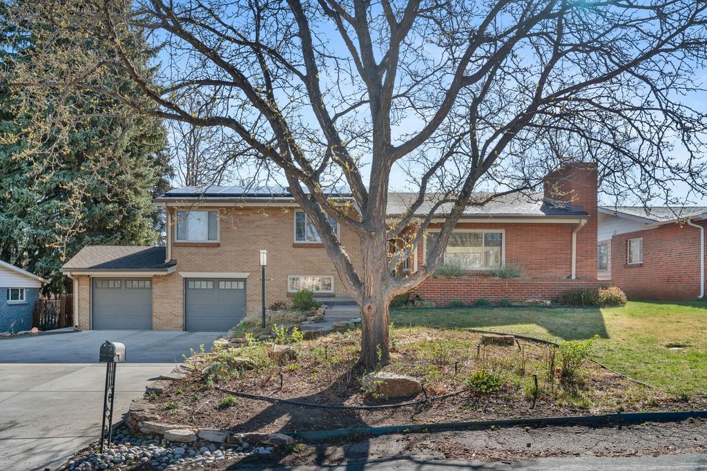 Brick ranch home in the Denver area with bare winter trees and a clear blue sky