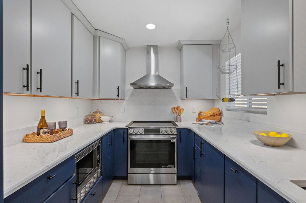 Remodeled kitchen with quartz counters, navy cabinets and stainless appliances in Wellshire, Denver