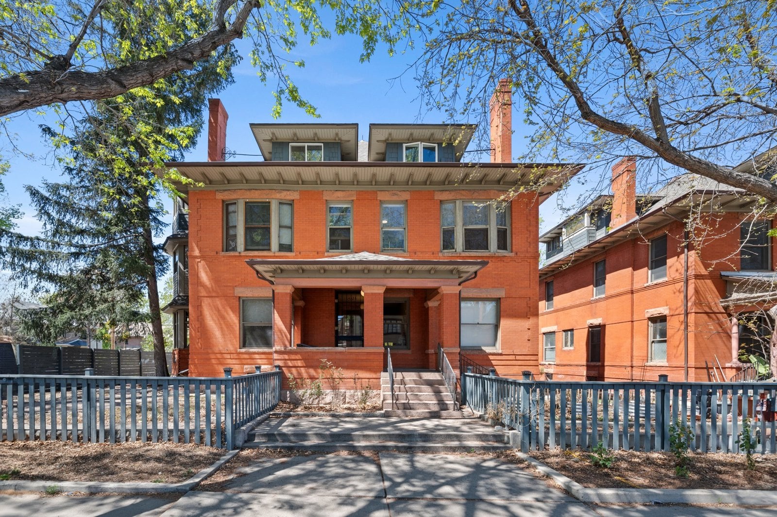Historic red brick Denver Square home with a front porch in Denver