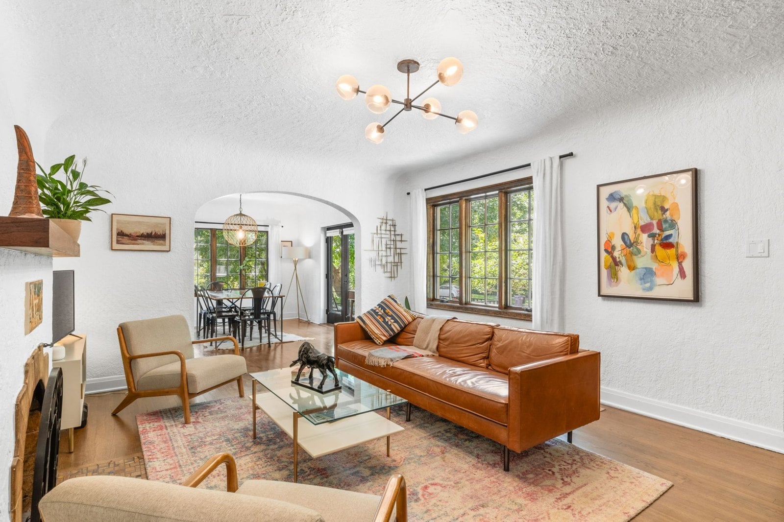 Living room with hardwood floors and arched windows in an older Denver bungalow