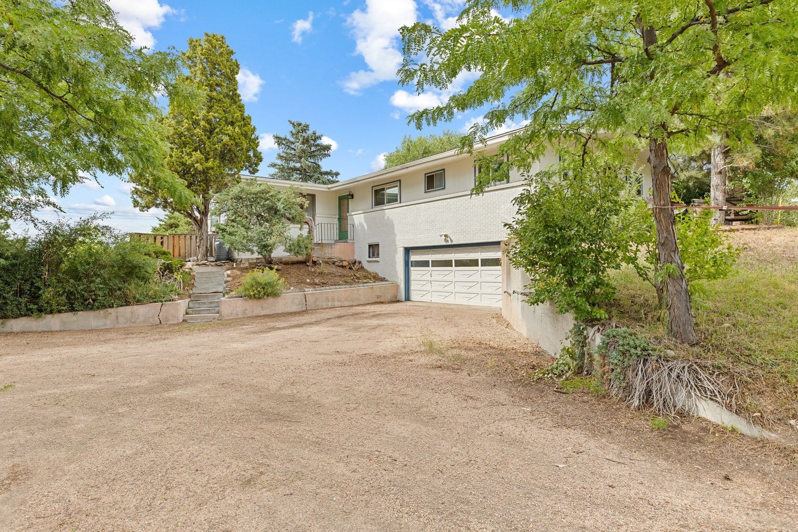 Ranch home with long driveway and mature trees on Denver's west side near Applewood