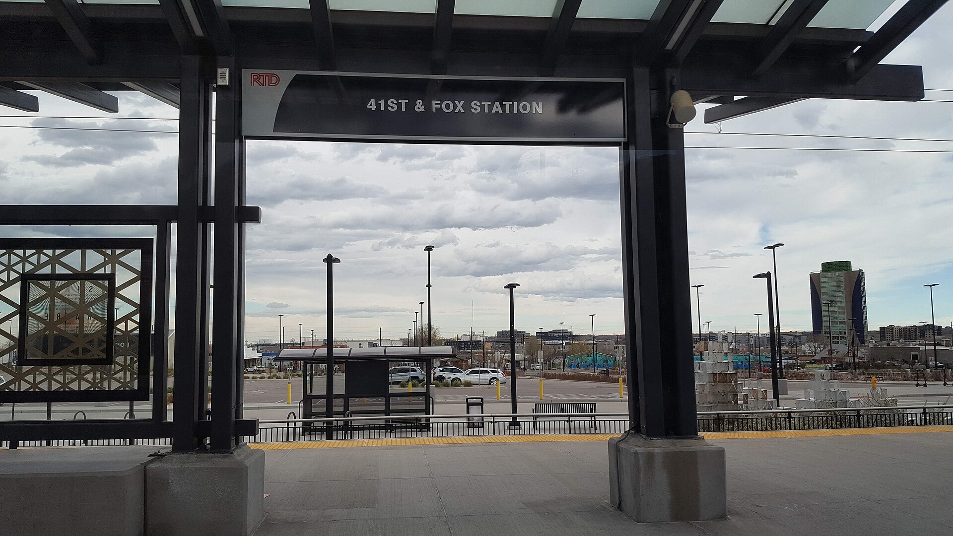 41st & Fox Station platform sign and canopy, with the station parking lot and low buildings beyond
