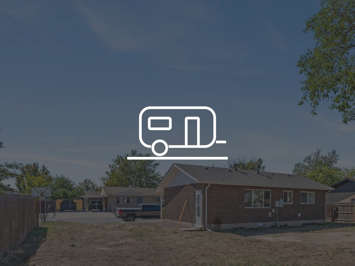 Backyard and brick ranch at 5504 Sable St in Montbello, Denver, with a camper icon for RV parking