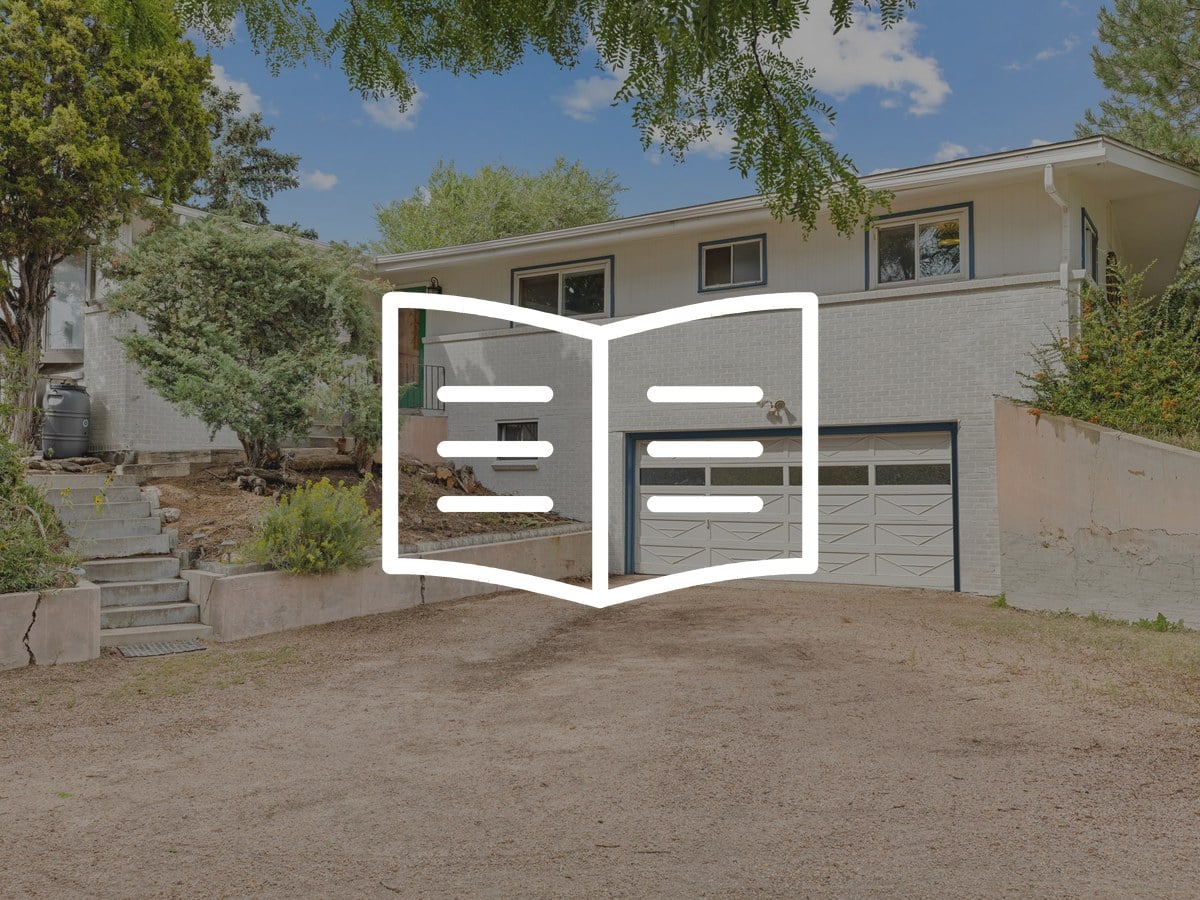 Painted brick split-level home with a two-car garage and a sunny front yard