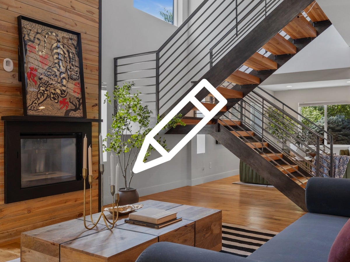 Modern living room with a wood-paneled fireplace wall and an open steel staircase