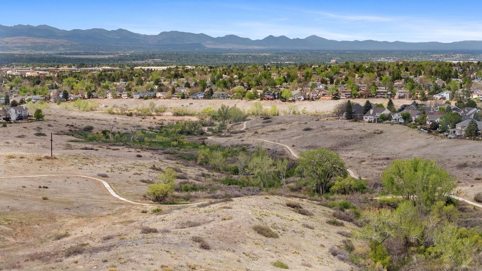Open space trail winding through grassland with a foothills view in the Denver metro