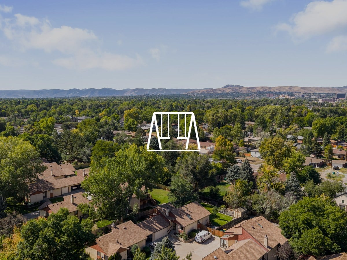 Aerial view of tree-covered residential streets with the foothills on the horizon