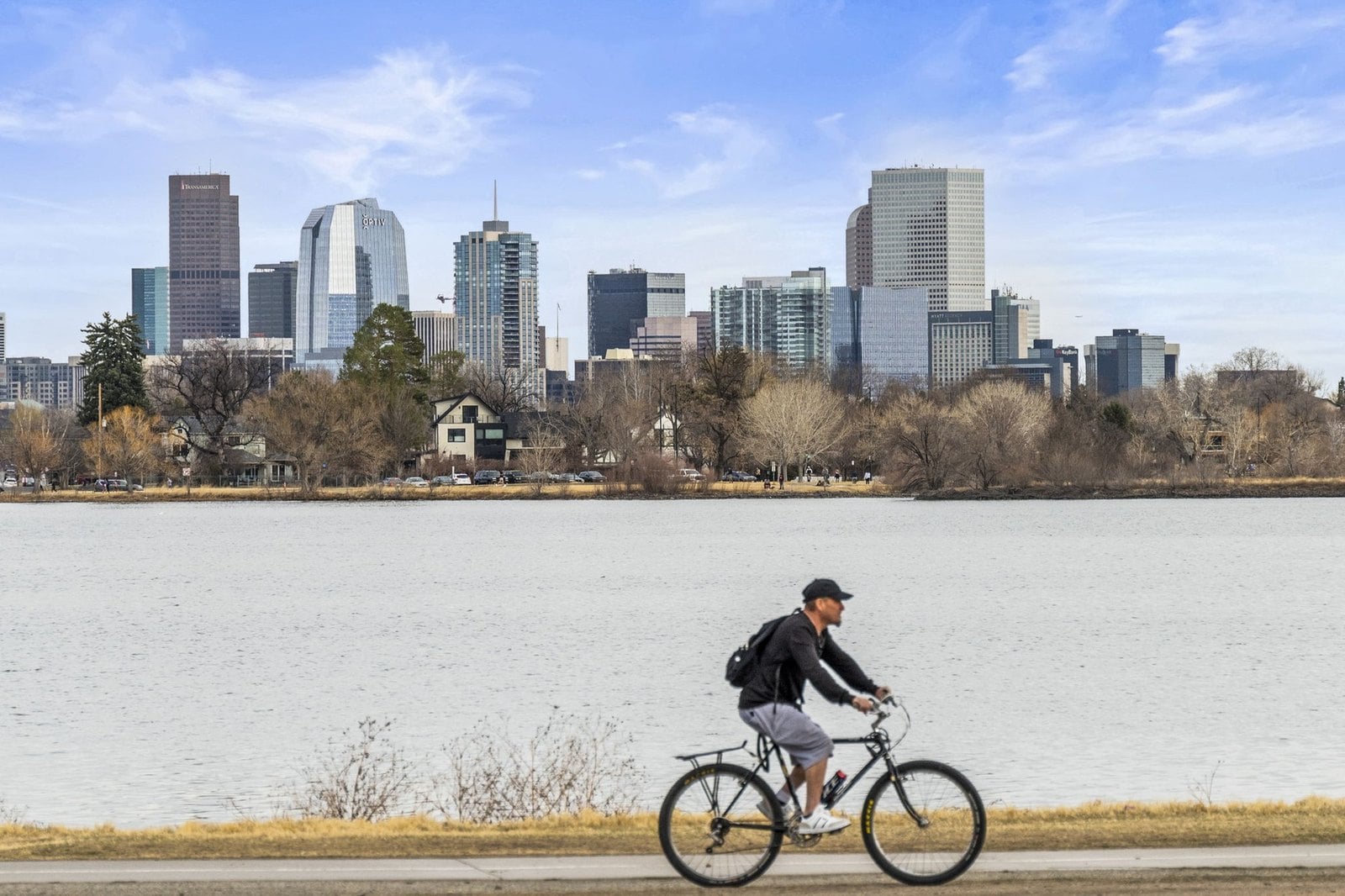 Cyclist on the lake path at Sloan's Lake with the Denver skyline behind