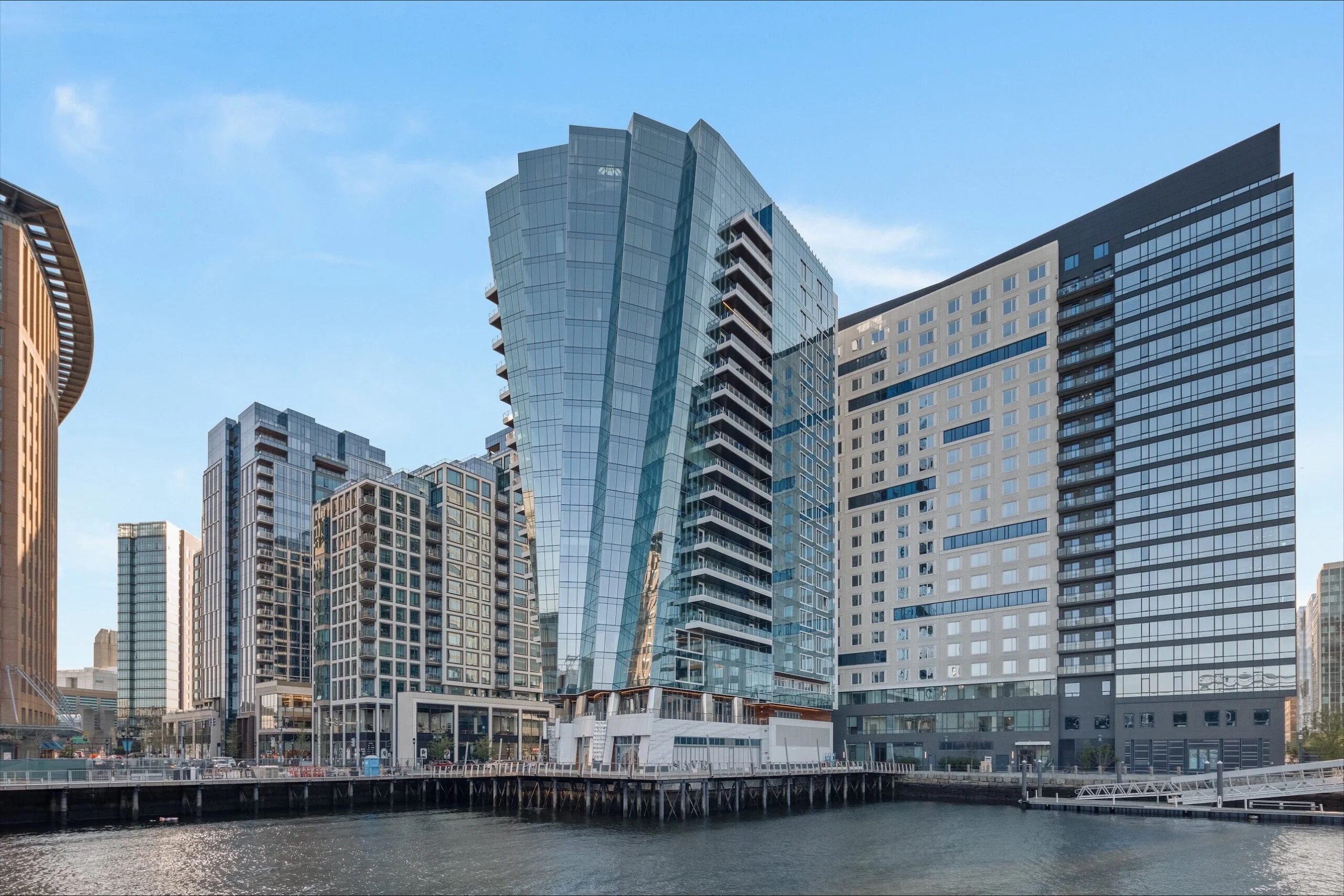 Interior view of Boston’s St. Regis super penthouse, spanning over 10,000 sq ft with floating staircase, glass walls and harbor views in a $49.5 million listing.