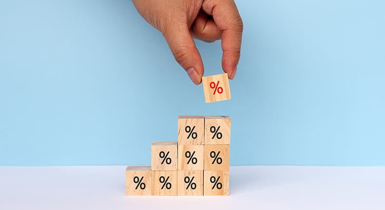 Hands Stacking Percent Signs on Wood Toy Block