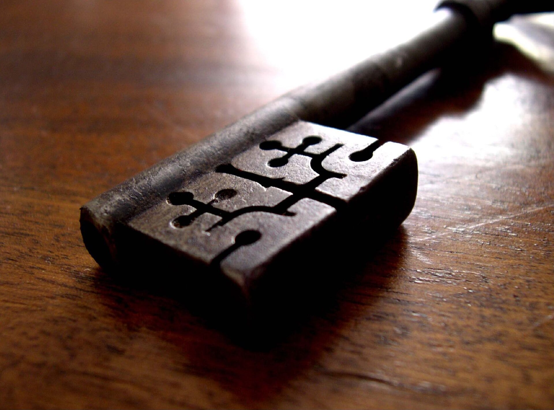 Old metal key lying on a wooden table