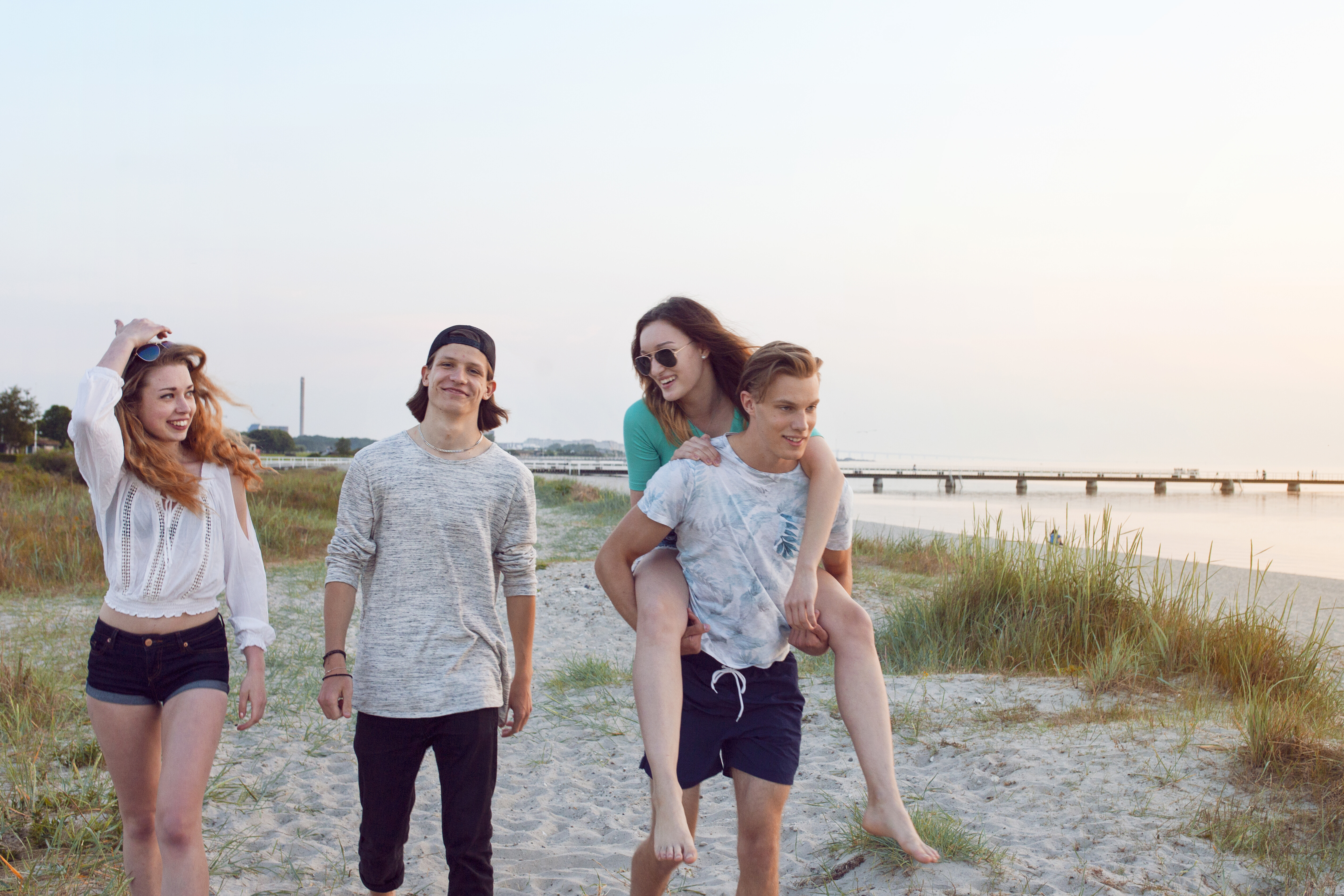 Friends enjoying a carefree walk on the beach at sunset