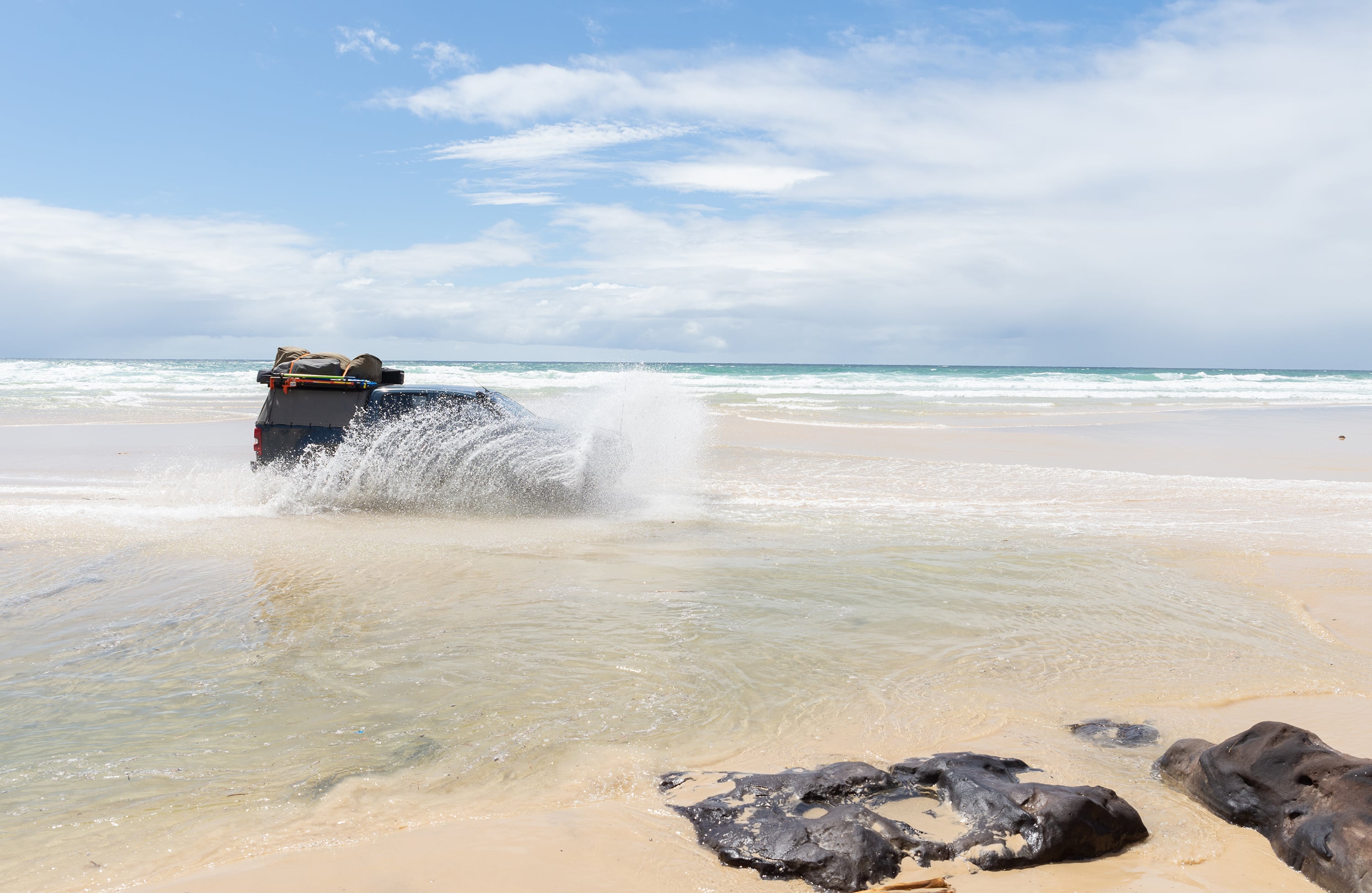 four-wheel-drive-crossing-a-creek-on-a-beach-in-fr-2024-12-06-09-35-57-utc