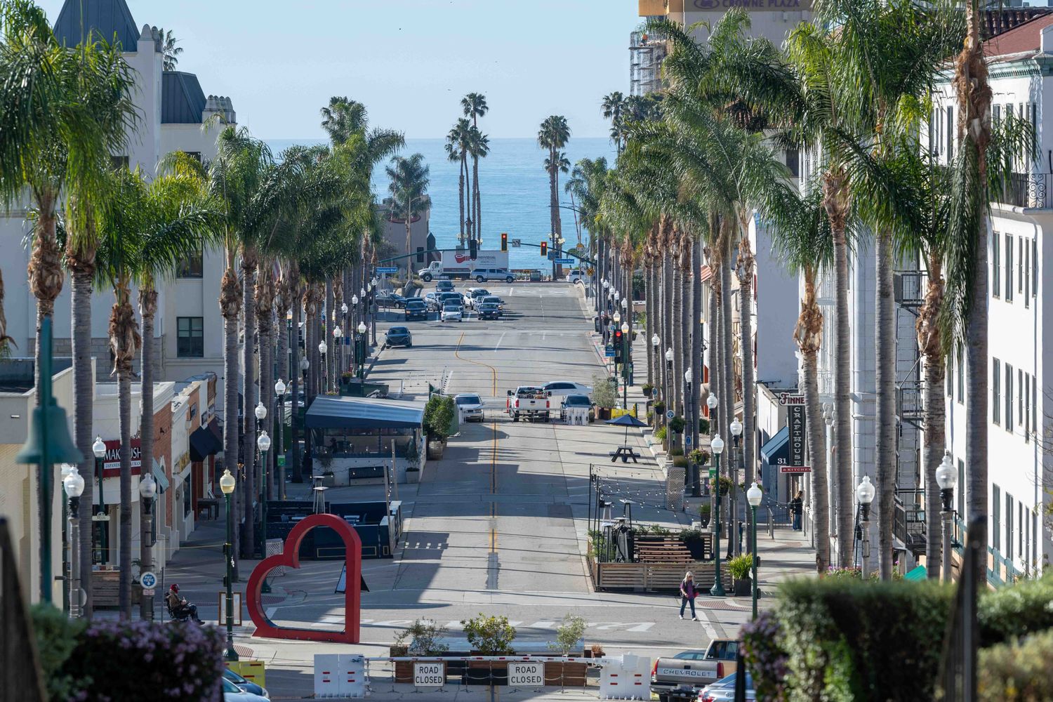Palm-lined street in Downtown Ventura with hills in the background