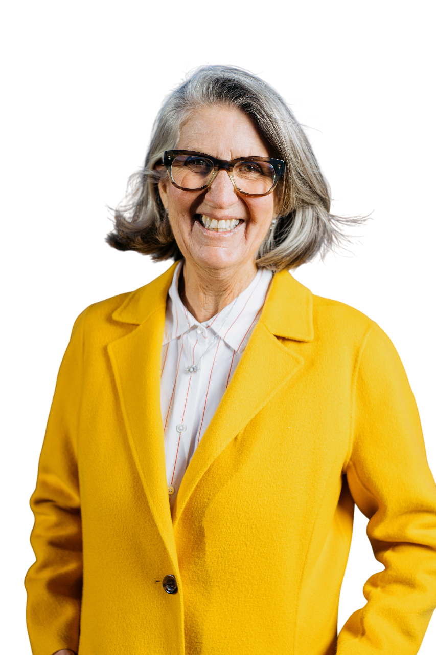 April Ralph, REALTOR, smiling in a bright yellow coat, facing the camera against a transparent background.